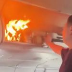 Moment flames erupt in plane cabin after battery in overhead luggage combusts as flight forced to make emergency landing