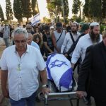Israeli flag drapes coffin of hostage who died in Hamas captivity as his body is returned home