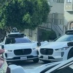 Excruciating moment three self-driving taxis clog up street and stop moving after getting into AI standoff