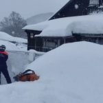 Entire buildings buried in MASSIVE snow drifts as mega blizzards kill at least two and locals forced to dig out of homes
